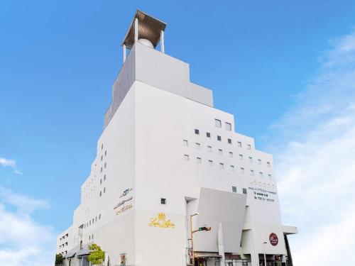 a white building with a cross on top of it at ホテルレイクアルスターアルザ泉大津 in Izumiotsu