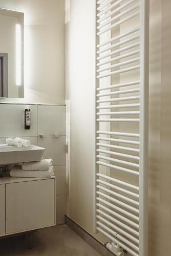 a bathroom with a glass shower door with a sink at Die Meissen Lodge in Meißen