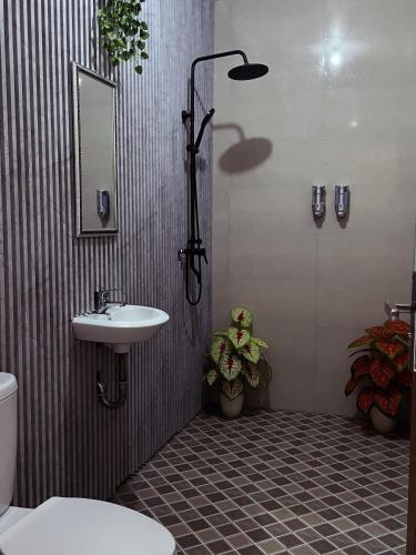 a bathroom with a sink and a toilet and a shower at Green Merta in Padangbai