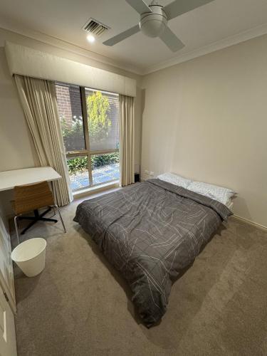 a bedroom with a bed and a large window at Homestay - Room for Rent Bundoora in Melbourne