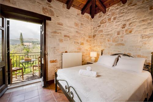 a bedroom with a large bed and a balcony at Grantzaos Villas in Laganas