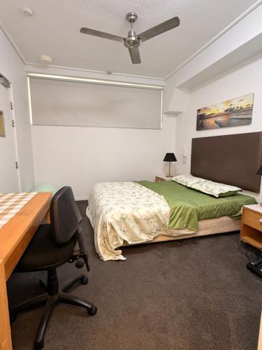 a bedroom with a bed and a desk and a chair at TJ Homes in Ross Island