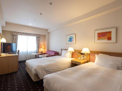 a hotel room with two beds and a television at ホテルレイクアルスターアルザ泉大津 in Izumiotsu
