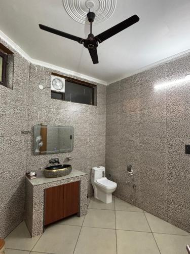 a bathroom with a ceiling fan and a toilet at GardenView Hotel and Resort in Dhantori