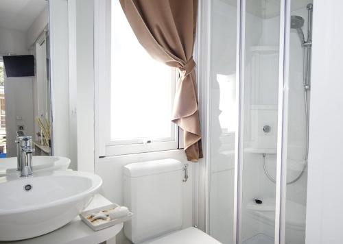 a bathroom with a toilet and a sink and a window at Camping Village Baia Azzurra in Castiglione della Pescaia