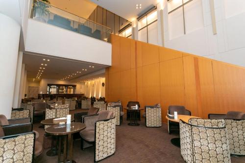 a restaurant with tables and chairs and a large wall at ホテルレイクアルスターアルザ泉大津 in Izumiotsu