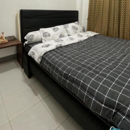 a bed with a black frame and white sheets and pillows at Rama Shinta Guesthouse & Coffee Yogyakarta in Yogyakarta