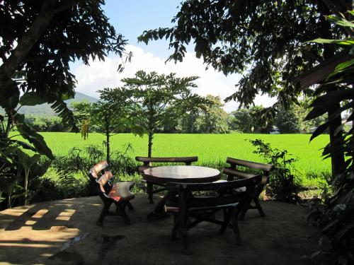 a table and chairs with a field in the background at XPai in Pai
