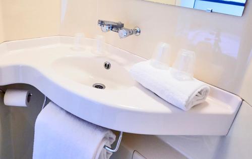 ナンテールにあるプルミエール クラッス パリ ウエス ナンテール ラ デファンスの白いバスルーム(タオル付き洗面台付)
