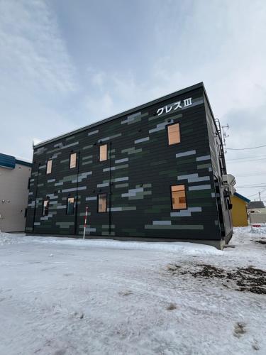 a building that is painted green and brown at Cress 3 in Biei
