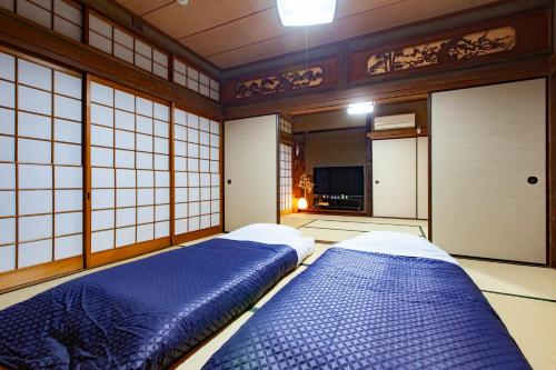 a room with two beds in a room with windows at Guest Room Kanda in Suo Oshima