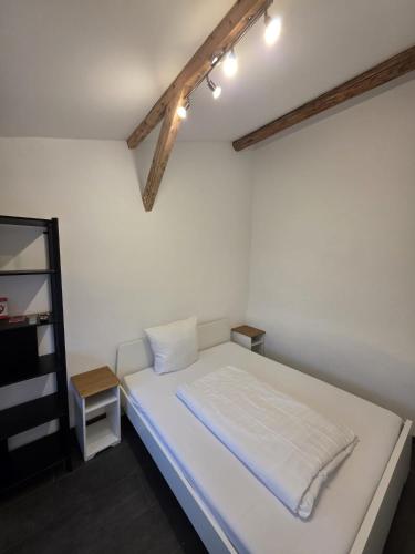 a bedroom with a white bed and a shelf at Maimühle Appartements in Perl
