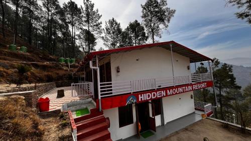 a building with a sign that reads hidden mountain resort at Hidden Mountain Resort in Almora