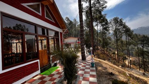 a house with a checkered floor and a plant on a porch at Hidden Mountain Resort in Almora