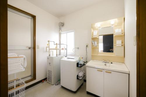 HanazonomachiにあるROOMzero 1号室の冷蔵庫と洗面台付きのバスルーム