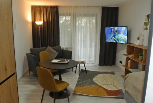 a living room with a couch and a table and a tv at Kemnater Hof Apartments SELF-CHECK-IN in Ostfildern
