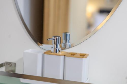 a bathroom sink with a mirror and two faucets at Curzon St Aparthotel in Derby