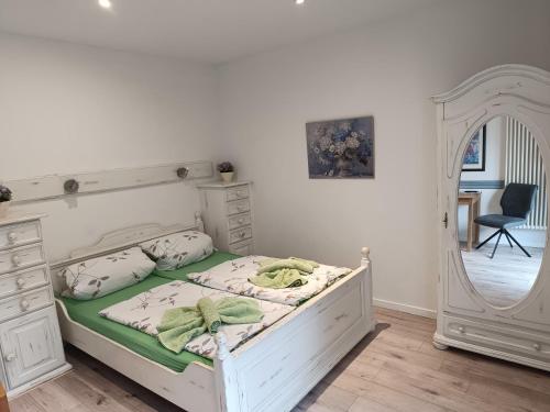 a bedroom with a white bed and a mirror at Kastanienhof Lübben in Lübben
