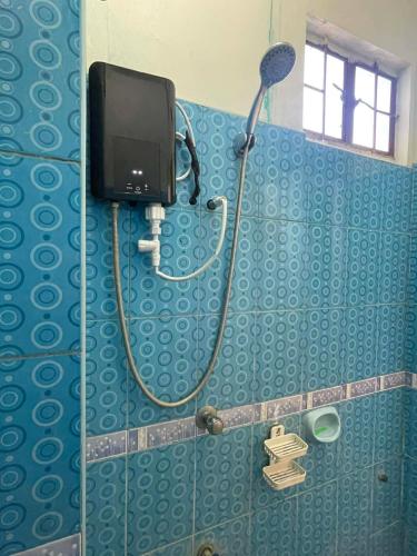 a bathroom with a shower with a tv on the wall at GSB City Apartelle in Tuguegarao City