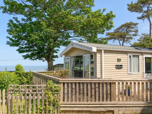 a tiny house with a wooden fence at Number 110 in West Quantoxhead