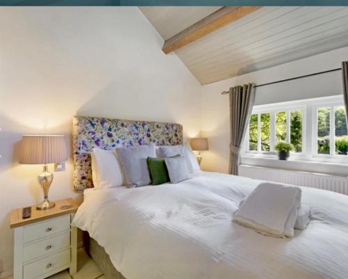 a bedroom with a large white bed and a window at Dove Cot country cottage Ambleside in Ambleside