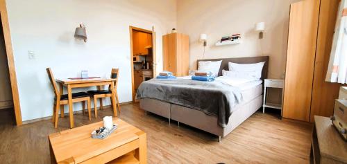 a small bedroom with a bed and a table at Haus Nordmeer in Borkum