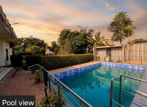 a swimming pool in front of a house at Shree Govindam kunj Villa in Jaipur