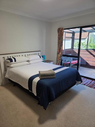a bedroom with a bed and a sliding glass door at Rooms in an Epsom House in Auckland