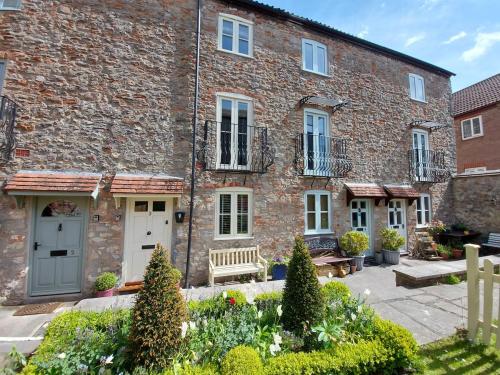 a brick building with a bench in front of it at St Etheldreda's Cottage, Wells, Somerset in Wells