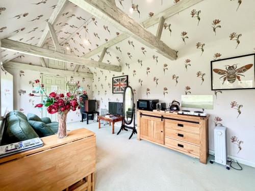 a living room with a table and flowers on the wall at Cottage 3 - Uk46609 in Broughton