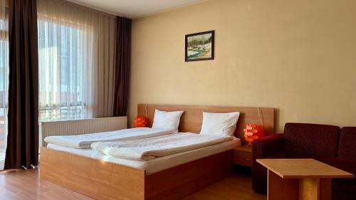 a bedroom with a bed and a couch and a window at Hotel Veronika Devin in Devin