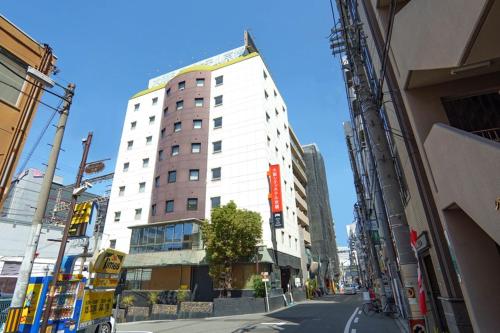 a tall white building on a city street at Osaka City Hotel Kyobashi in Osaka