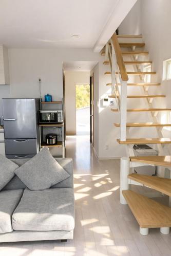 a living room with a couch and a staircase at Saraswati in Nakijin