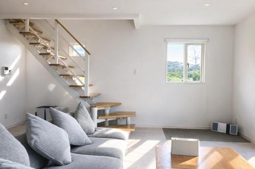 a living room with a couch and a staircase at Saraswati in Nakijin