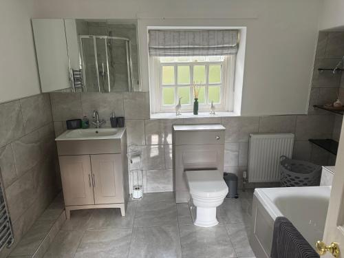 a bathroom with a toilet and a sink and a tub at West Cottage, Free Breakfast supplied with free range eggs With log burner in Towton