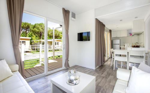 a living room with a white couch and a table at Camping Village Baia Azzurra in Castiglione della Pescaia
