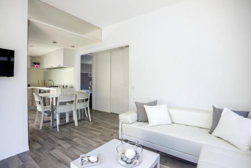 a living room with a white couch and a table at Camping Village Baia Azzurra in Castiglione della Pescaia