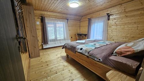 a bedroom with a bed in a log cabin at Cămăruța din Apuseni in Valea Ierii