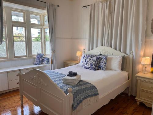 a bedroom with a white bed with blue and white pillows at Kent Street Retreat in Brisbane