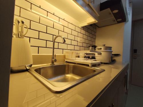 a kitchen counter with a sink and a stove at Naomi's Green Haven in Dasmariñas