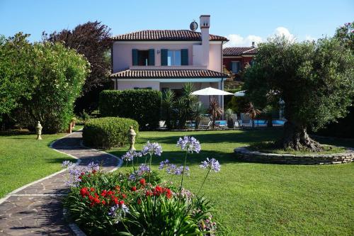 a house with a garden with flowers in the yard at Belvedere in Isola Albarella