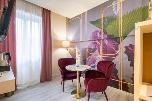 a room with two chairs and a table and a mural at Hotel Le Palme Lago Maggiore Bike Friendly in Dormelletto