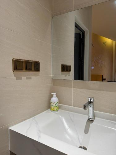 a bathroom with a white sink and a mirror at Mom Villa - Cẩm Thanh in Hiếu Nhơn