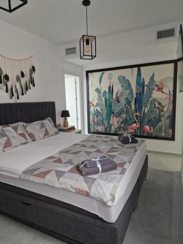 a bedroom with a large bed with a painting on the wall at Lassa Holiday Apartament in Torrevieja
