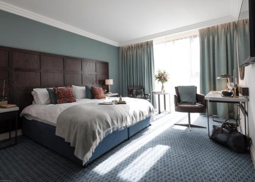 a bedroom with a large bed and a desk at Clayton Hotel Cambridge in Cambridge
