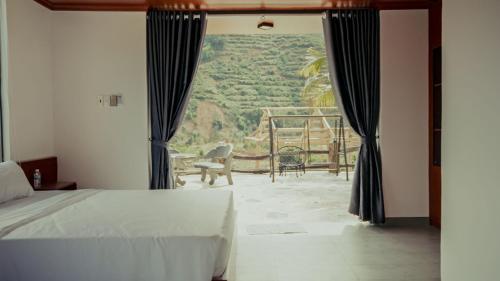 a bedroom with a bed and a window with a view at Homestay Minano in Mock Den