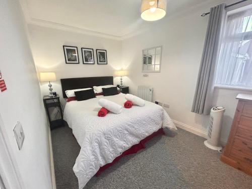 a bedroom with a bed with red pillows on it at The Nest at Wynncroft in Torquay