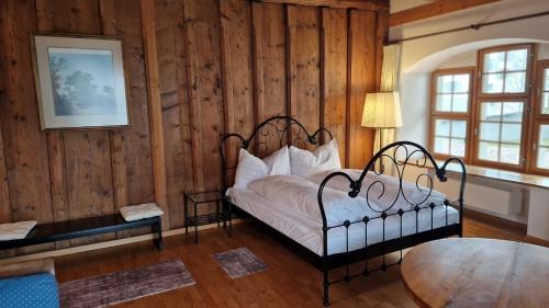 a bedroom with a bed in a room with wooden walls at NRAR Hotel Hirschen in Beromünster
