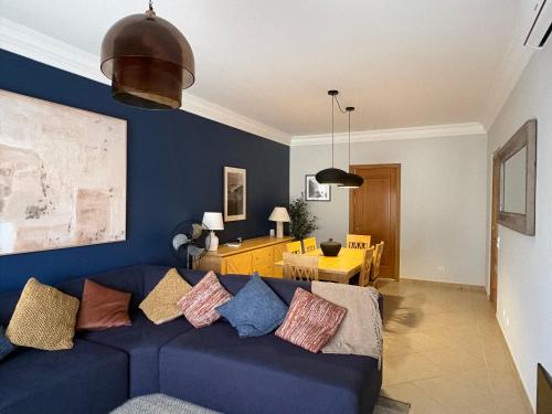 a living room with a blue couch with pillows at Fairviews Boavista , Boavista golf and spa resort Lagos in Lagos