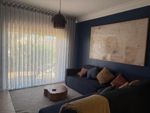 a living room with a blue couch and a table at Fairviews Boavista , Boavista golf and spa resort Lagos in Lagos
